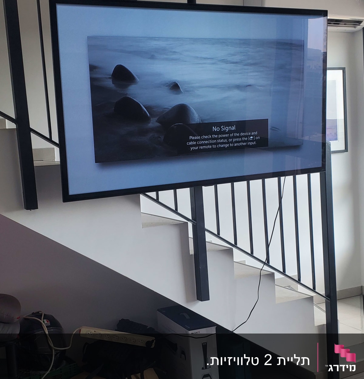 טלוויזיה מותקנת על קיר עם כבל חשמל תלוי